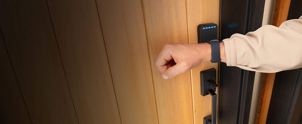 Un homme utilise sa Apple Watch avec la serrure intelligente Schlage Sense Pro compatible Apple Home Key pour déverrouiller d’un simple toucher